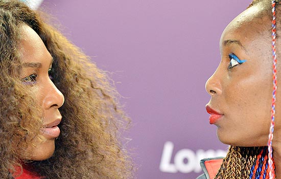 Venus Williams (esq.) conversa com sua irm Serena durante entrevista da equipe de tnis dos EUA em Londres