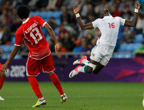 O jogador senegals Pape Souare sofre falta durante a partida contra os Emirados rabes pelo Grupo A