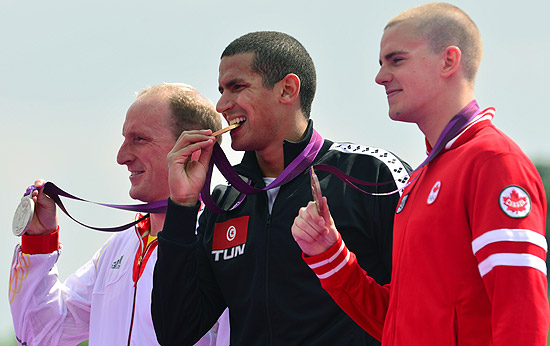 Mellouli (centro) morde a medalha de ouro entre o alemo Thomas Lurz (esq) e o canadense Richard Weinberger