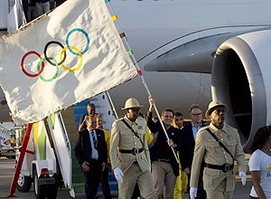 Prefeito Eduardo Paes chega com a bandeira olmpica no Rio (Silvia Izquierdo/Associated Press)