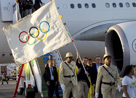 Eduardo Paes, prefeito do Rio, agita a bandeira olmpica aps desembarque no aeroporto Tom Jobim 