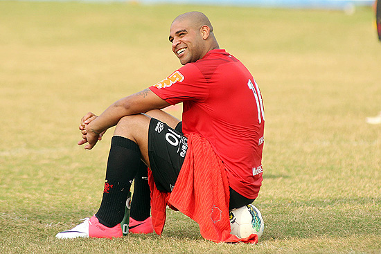 Adriano, atacante do Flamengo, senta na bola durante treino
