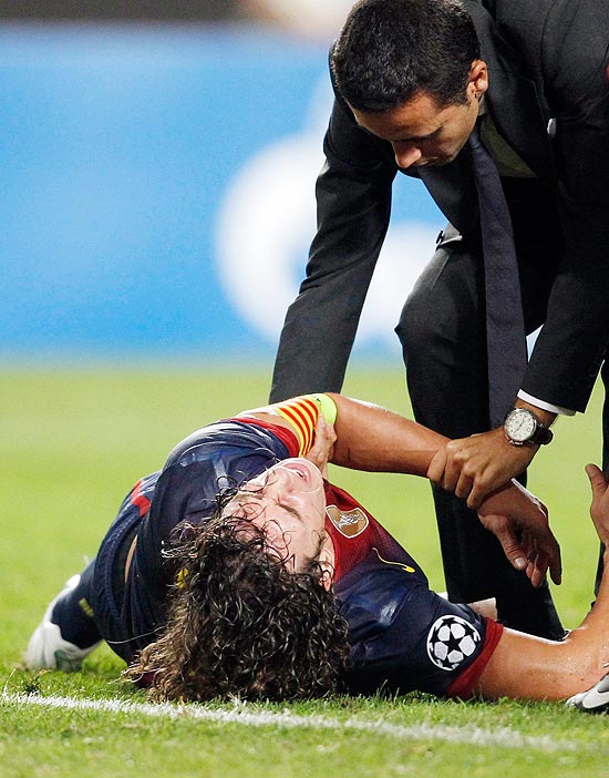Puyol  atendido aps machucar o brao em jogo do Barcelona