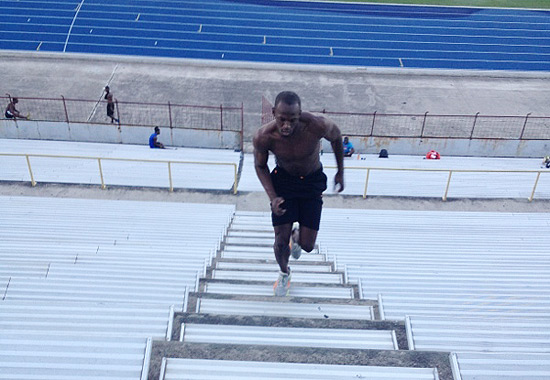 Usain Bolt sobe escadas de uma arquibancada durante um treino