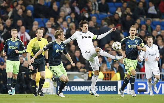 O brasileiro Kaká tenta dominar a bola marcado por rival do Ajax, no estádio Santiago Bernabéu