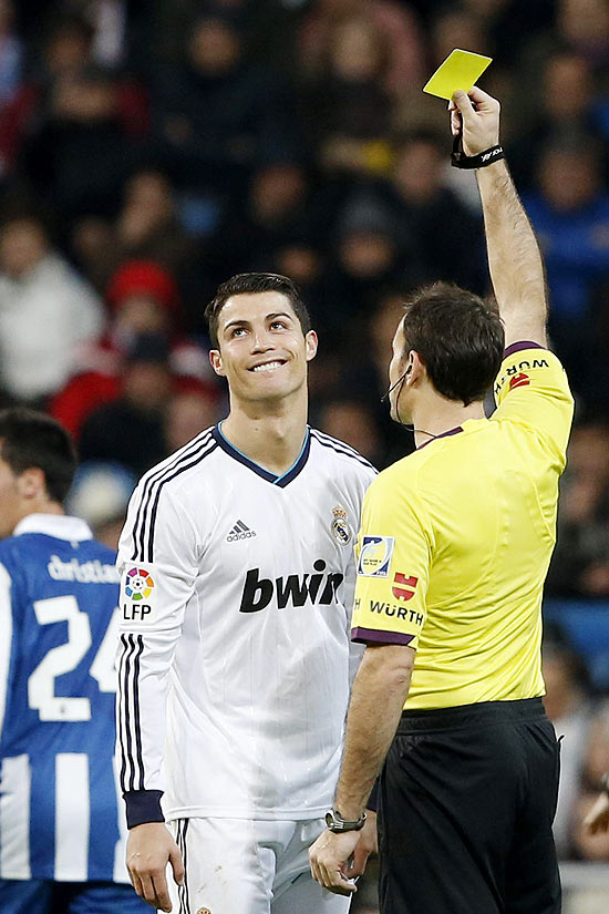 O árbitro Miguel Mateu Lahoz dá cartão amarelo a Cristiano Ronald em jogo do Real contra o Espanyol