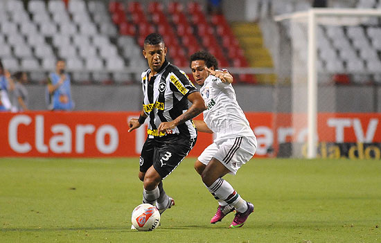 O botafoguense Antonio Carlos fica com a bola no combate contra Wellington Nem, que fez gol