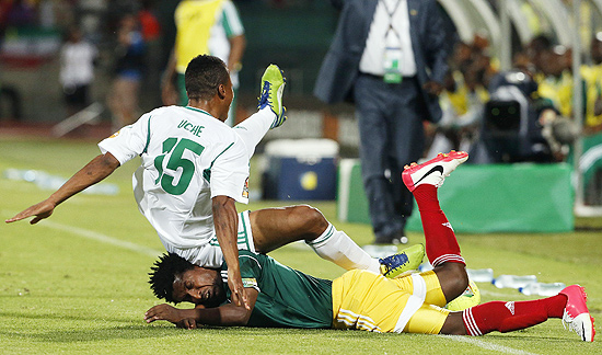 O etope Alula Girma  derrubado pelo nigeriano Ikechukwu Uche durante partida da Copa Africana de Naes