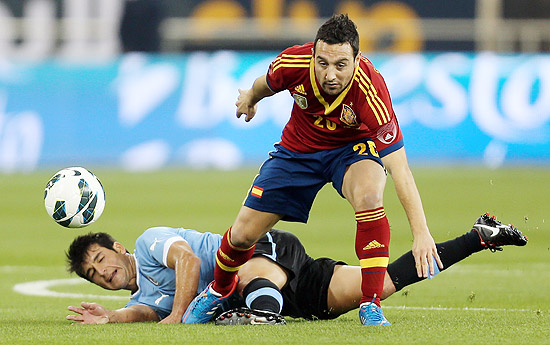 Cazorla, da Espanha, disputa bola com Lodeiro, do Uruguai, em amistoso disputado em Doha, no Qatar