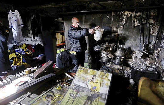 Meir Harush, membro do conselho do Betar Jerusalm, mostra objetos do clube queimado