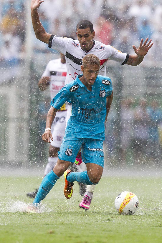 Neymar tenta escapar da marcação do jogador do Paulista