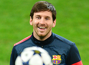 Messi sorri em brincadeira com a bola durante treino