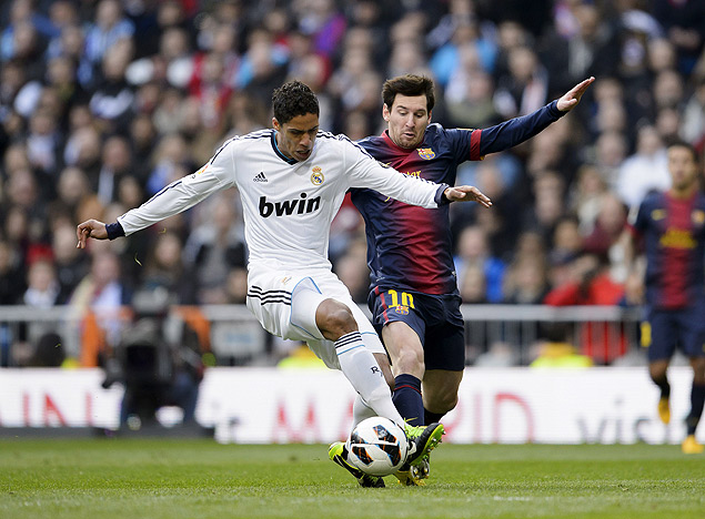 O zagueiro francs Raphael Varane, do Real, disputa jogada contra o argentino Lionel Messi, do Barcelona
