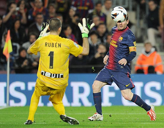 Messi (à dir.) encobre o goleiro Ruben na vitória do Barcleona por 3 a 1 sobre o Rayo Vallecano