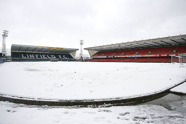 Gramado do estádio Windsor Park fica coberto de neve em Belfast
