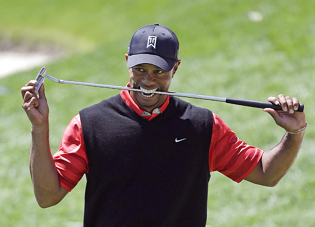 O golfista americano Tiger Woods morde o taco após garantir a volta ao topo do ranking mundial