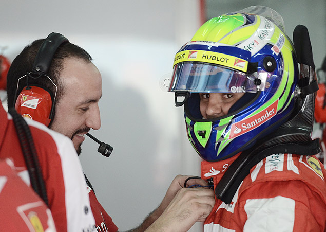 Funcionrio da Ferrari ajuda Felipe Massa a se preparar para o treino 
