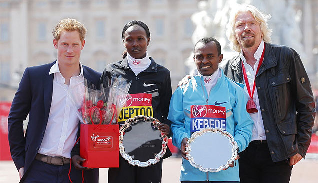 Prncipe Harry (esq.) posa com os vencedores da Maratona de Londres, Priscah Jeptoo e Tsegaye Kebede, e com um patrocinador