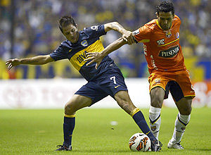 Martnez (esq.) disputa bola em jogo da Libertadores