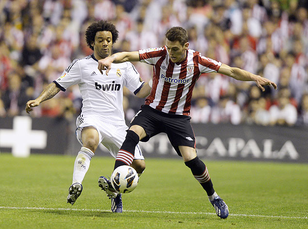 O lateral esquerdo Marcelo (esq.), do Real Madrid, luta pela bola com Gomez, do Bilbao, em jogo do Campeonato Espanhol