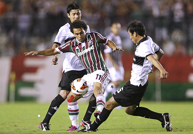 Wellington Nem (esq.) disputa a bola com Herminio Miranda, do Olimpia, na partida no Rio
