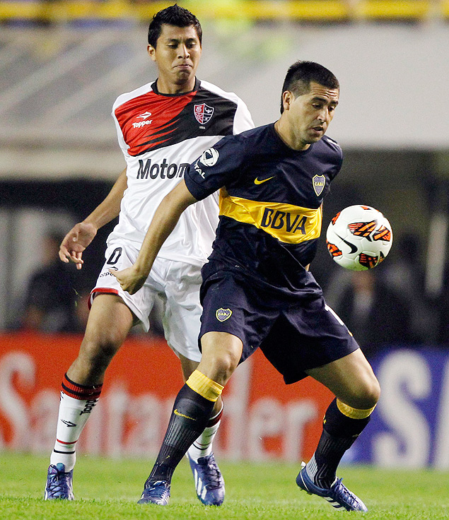 Sob marcao de Cruzado (esq.), Riquelme domina a bola em jogo entre Boca Juniors x Newell's Old Boys, pela Libertadores