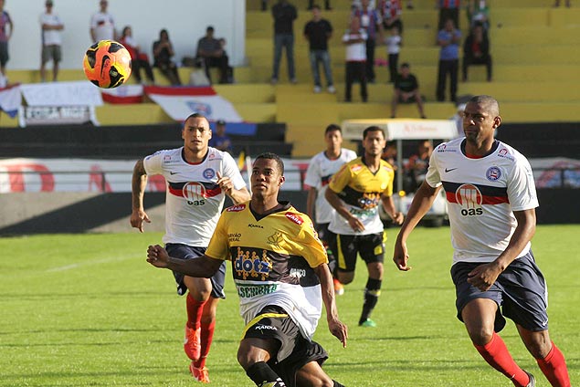 Lins (centro), jogador do Cricima, avana com a bola, enquanto  marcado por dois homens do Bahia