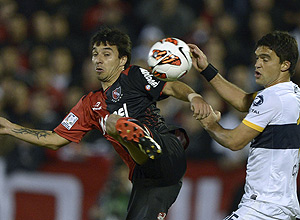 Ignacio Scocco (esq.) disputa jogada contra rival do Boca