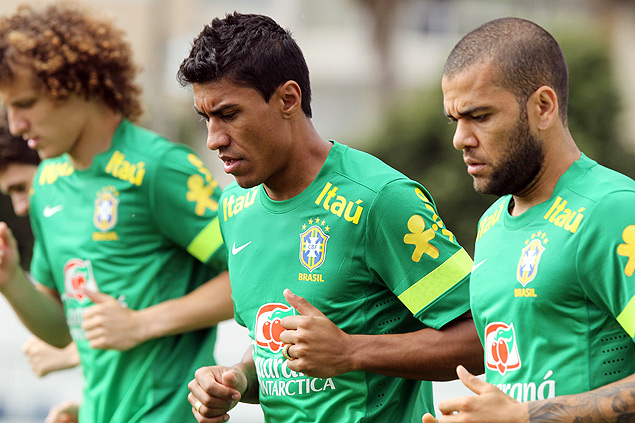 Daniel Alves (dir.) corre ao lado de Paulinho e David Luiz durante treino da seleo, em Goinia