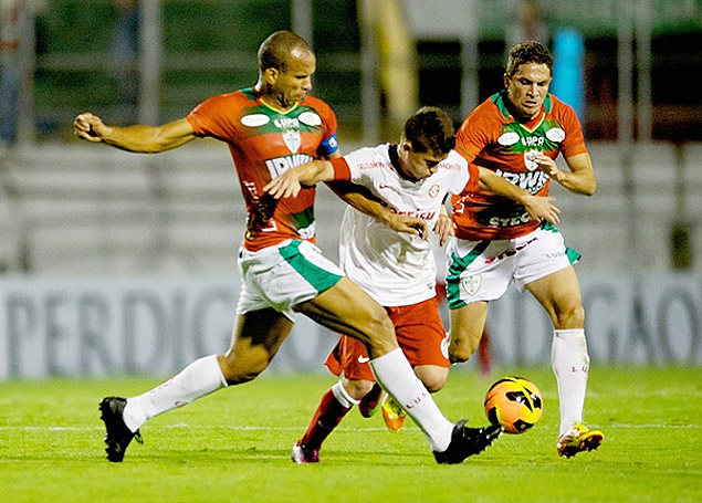Otvio (centro) tenta passar pela marcao da Portuguesa durante partida pelo Campeonato Brasileiro, no Canind