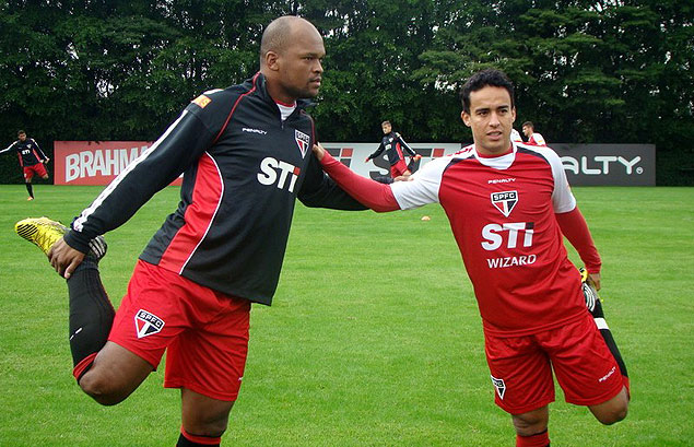 Jadson (dir.) faz alongamento com o zagueiro Edson Silva no CCT do So Paulo