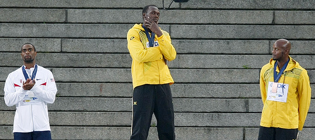 Asafa Powell (dir.) observa Usain Bolt, junto com Tysoin Gay, em pdio dos 100m do Mundial de Atletismo de Berlim
