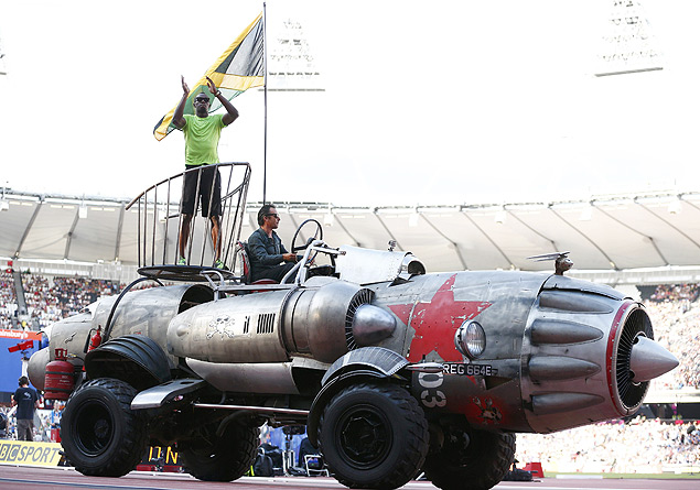 O velocista jamaicano Usain Bolt acena para o público no estádio olímpico de Londres sobre um veículo em forma de foguete