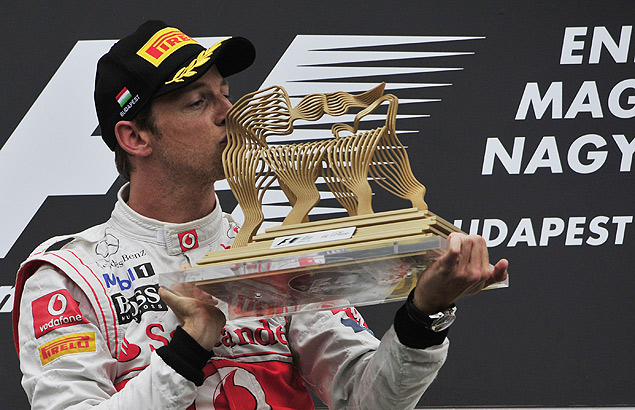 O ingls Jenson Button beija a taa conquistada na Hungria em 2011, j pela McLaren
