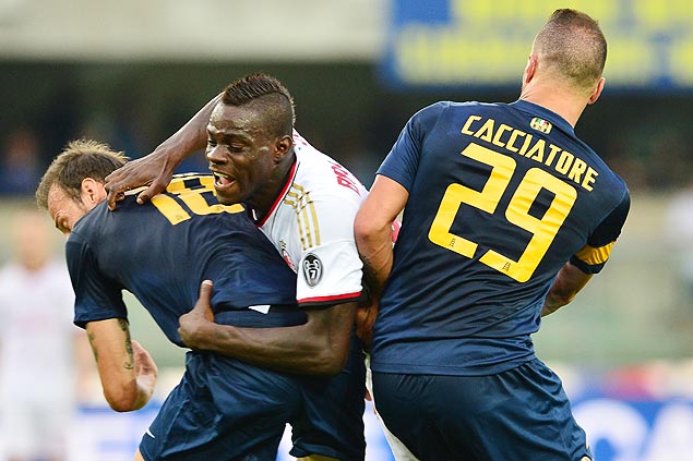 O atacante Mario Balotelli tenta passar pela marcação de Moras (esq.) e Cacciatore, do Verona