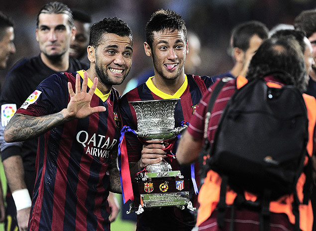 Neymar (dir.) e Daniel Alves posam para foto com a taa da Supercopa da Espanha