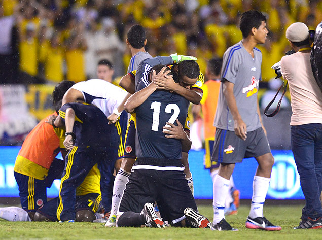 Jogadores colombianos se ajoelham e se abraçam após o apito final
