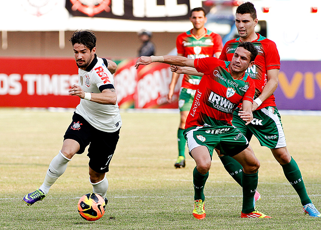 O atacante Pato, do Corinthians, disputa a bola com o volante Ferdinando, da Portuguesa, no Moreno