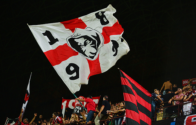 Torcedores do Milan agitam bandeira durante uma partida no estdio San Siro, em Milo
