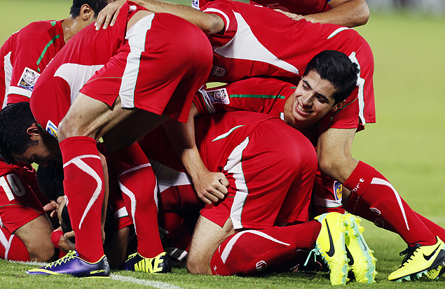 Jogadores iranianos comemoram gol diante da ustria em Al-Ain