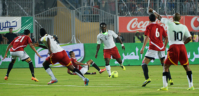 O ganense Essien (ao centro) conduz a bola durante o jogo contra o Egito no Cairo