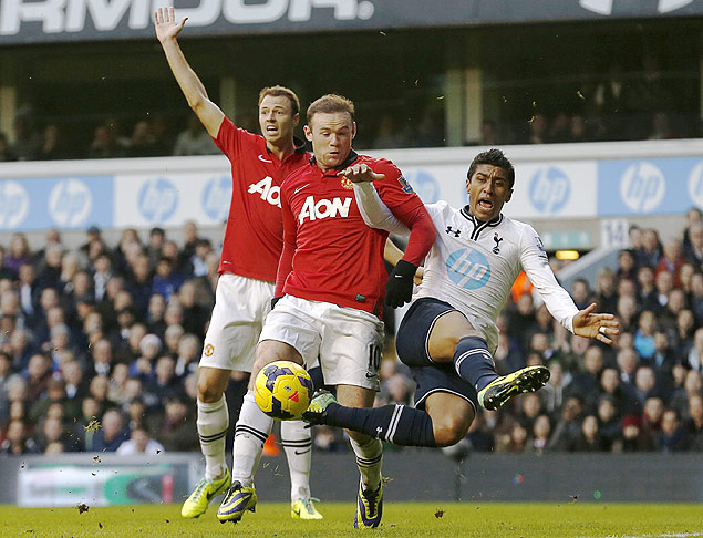 O volante Paulinho (dir.), do Tottenham, disputa bola com o atacante Rooney, do Manchester United