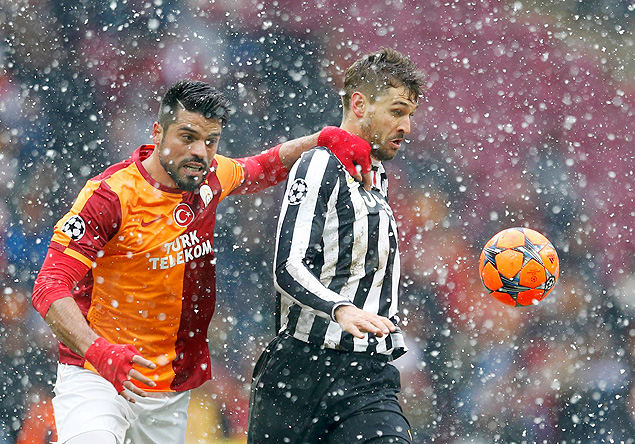 Gokhan Zan (esq.), do Galatasaray, disputa bola com Fernando Llorente, da Juventus