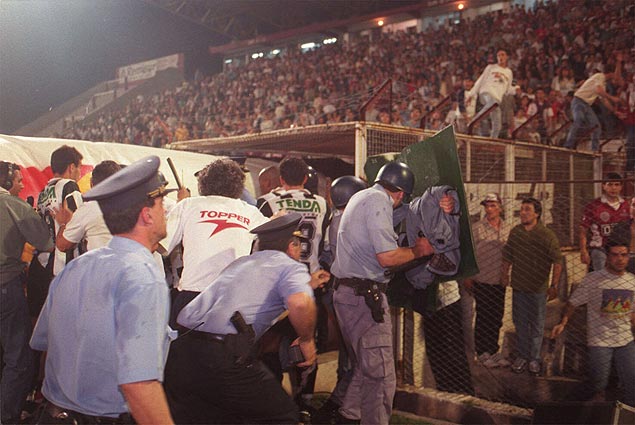 Policiais tentam proteger jogadores do Atltico-MG em briga com atletas e torcedores do Lans, em 1997