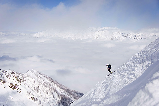 Esquiador desce um monte nevado em Rosa Khutor