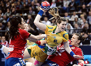 A brasileira Deonise Cavaleiro é agarrada por jogadoras sérvias em partida em que<br> o Brasil conquistou o Mundial de handebol