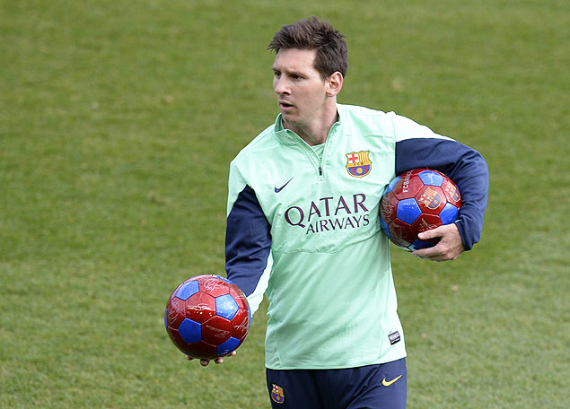 O meia-atacante argentino Messi segura a bola durante treino do Barcelona