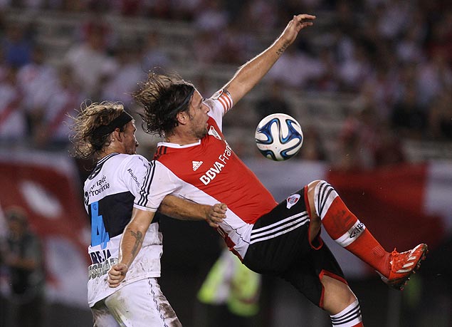 Cavenaghi ( direita), do River Plate, protege a bola diante de Oreja, do Gimnasia, na rodada inaugural do Argentino