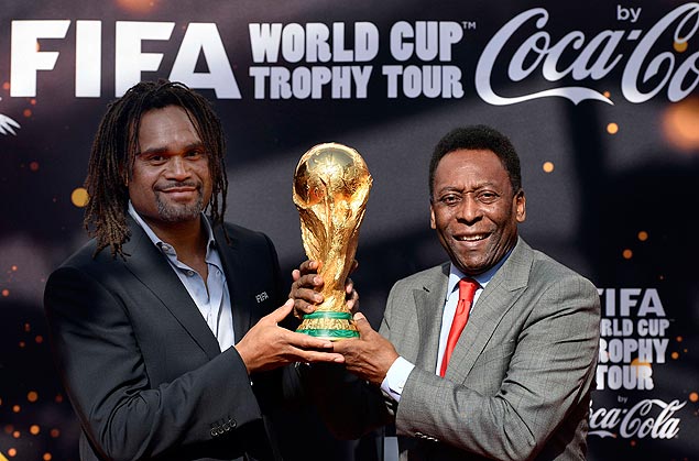 Pele and former French international football player Christian Karembeu pose with the FIFA World Cup trophy during the Trophy Tour