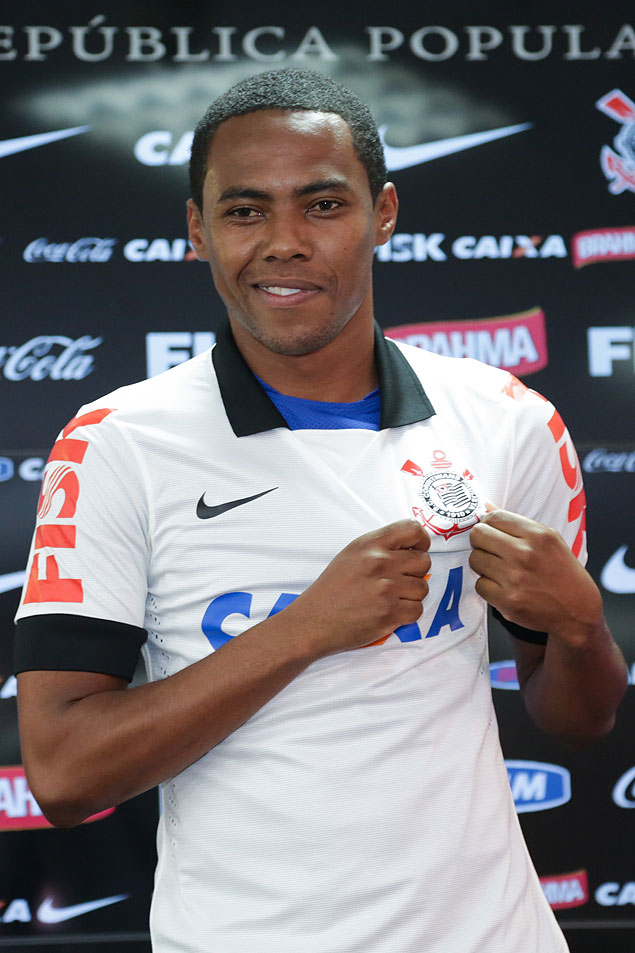 O volante Elias mostra o escudo do Corinthians em sua apresentação no clube